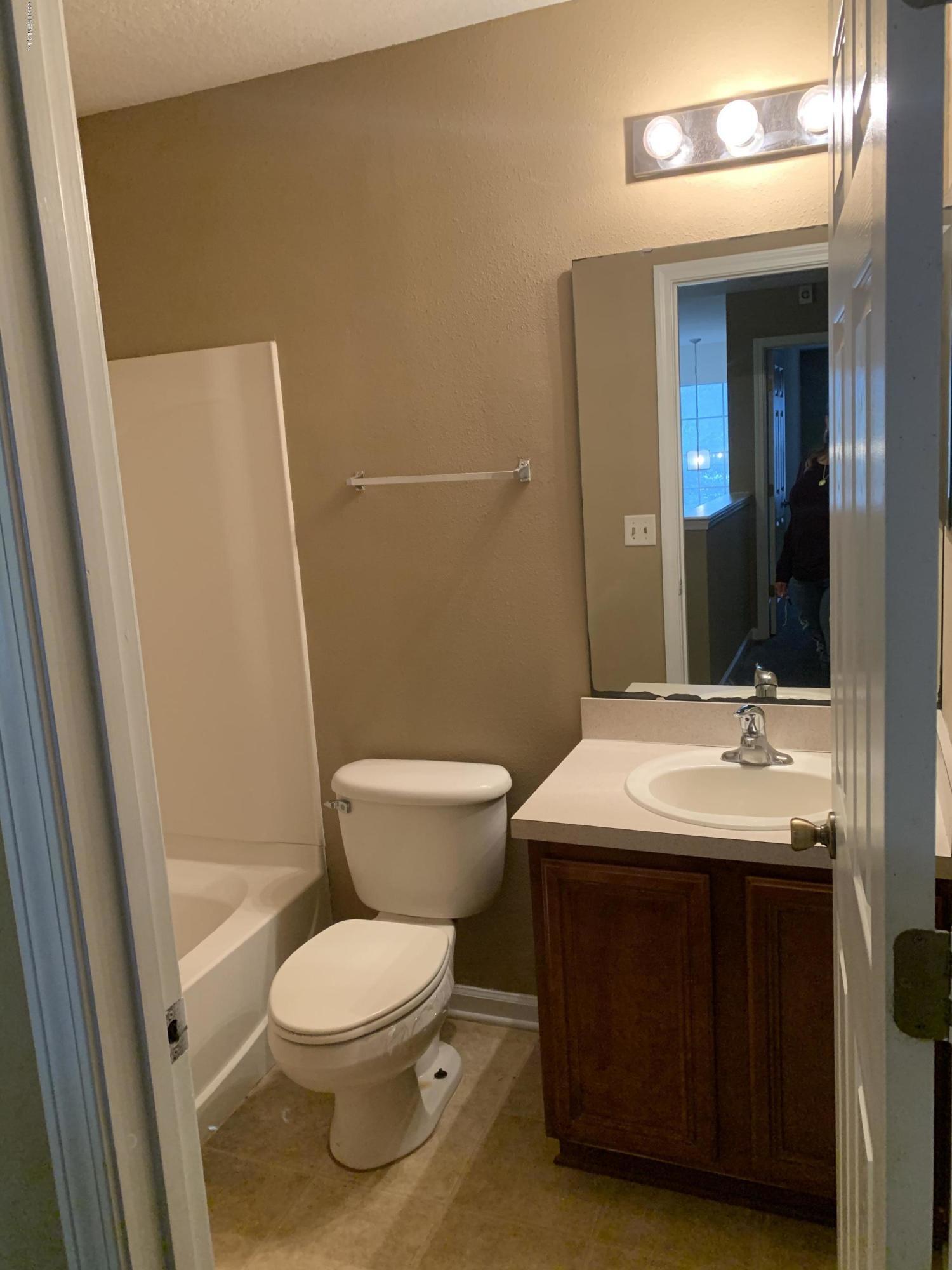 7140 Rampart Ridge Circle West Jacksonville, FL 32244 - Photo 6 of 13 a bathroom with a toilet a sink and a mirror