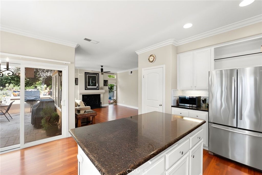 28561 Camelback Road Trabuco Canyon, CA 92679 - Photo 19 of 66 a kitchen with stainless steel appliances granite countertop a refrigerator a stove and a sink with wooden floor
