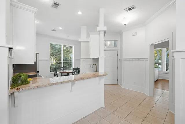 a kitchen with granite countertop white cabinets and white appliances
