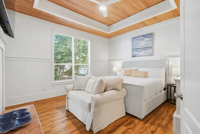 a large bedroom with a bed and a flat tv screen on wall