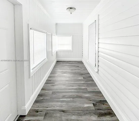 a view of a hallway with wooden floor and staircase