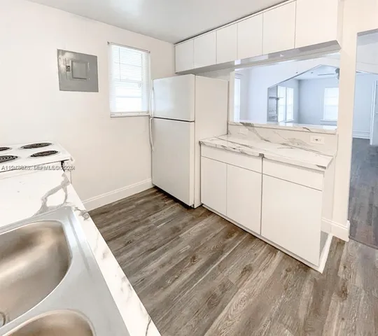 a kitchen with a refrigerator stove and white cabinets