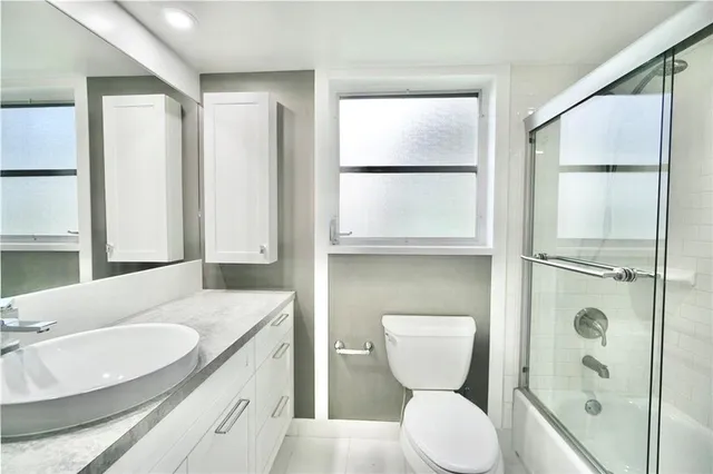 a bathroom with a granite countertop sink toilet and shower