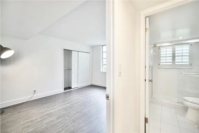 a view of a bathroom with wooden floor and a window