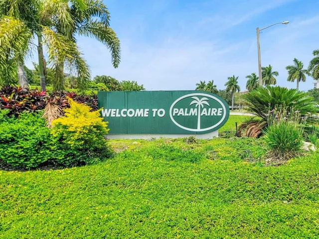 a sign that is sitting in the grass next to a road