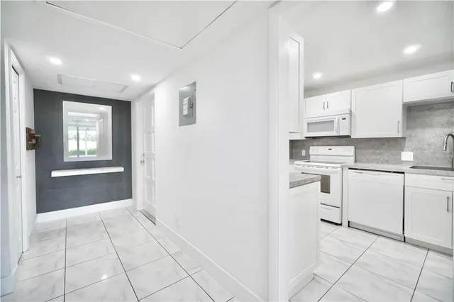 a kitchen with white cabinets and appliances