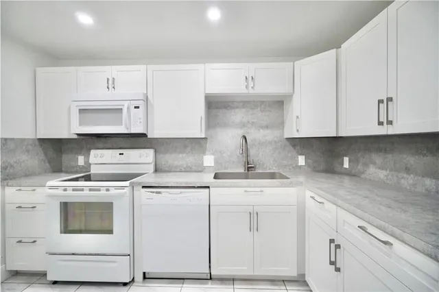 a kitchen with cabinets appliances and a sink