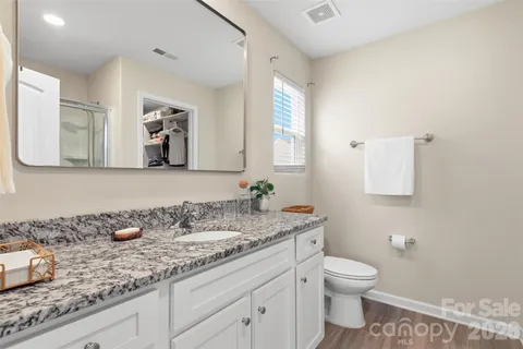 a bathroom with a granite countertop sink mirror and toilet