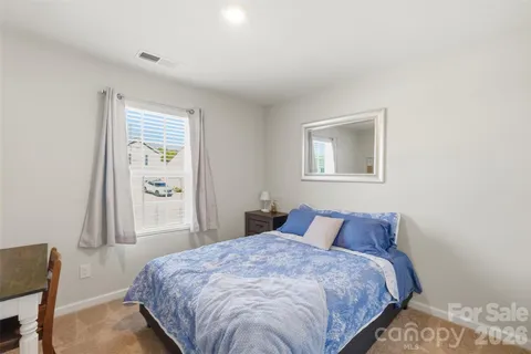 a bedroom with a bed and painting on the wall