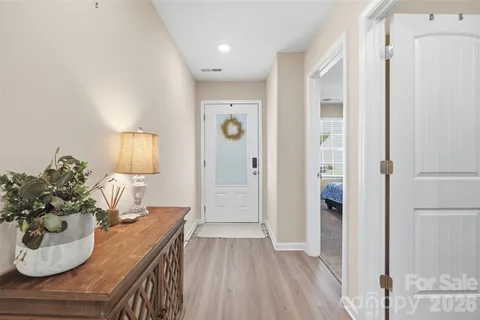 a view of a hallway and room with wooden floor