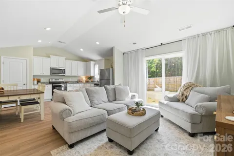 a living room with furniture kitchen and a large window