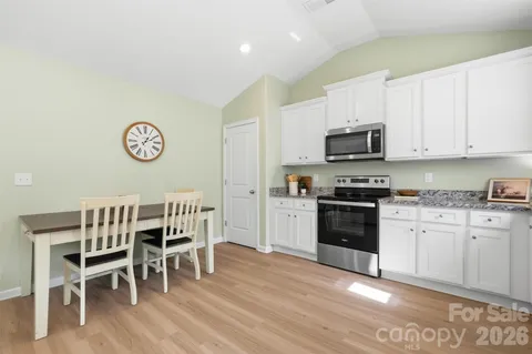 a kitchen with granite countertop a stove top oven microwave and cabinets