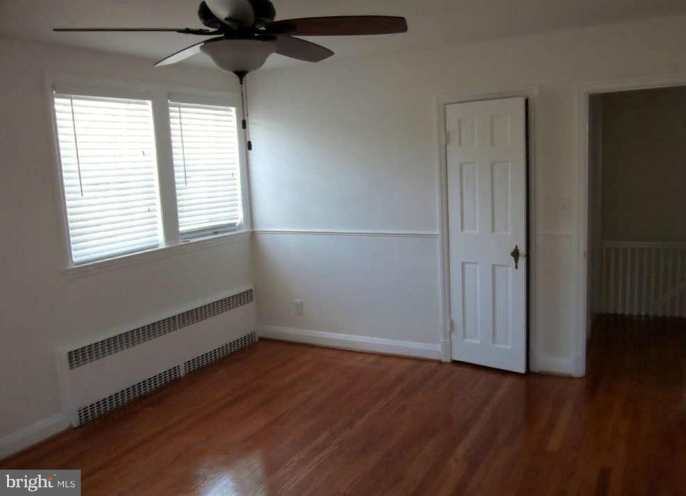 8412 Old Harford Road Baltimore, MD 21234 - Photo 12 of 25 an empty room with wooden floor fan and windows