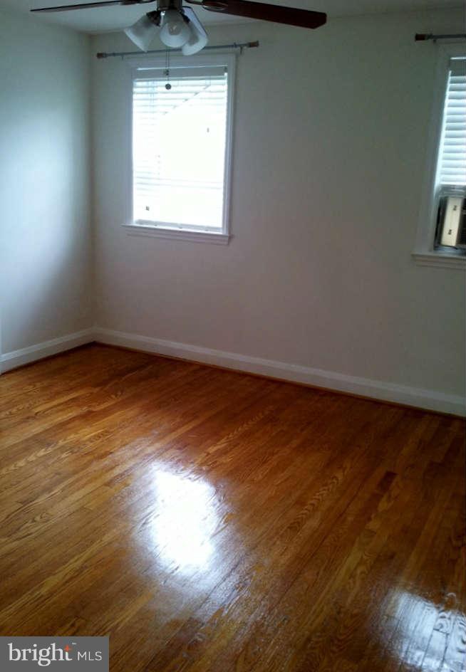 8412 Old Harford Road Baltimore, MD 21234 - Photo 13 of 25 an empty room with wooden floor and windows