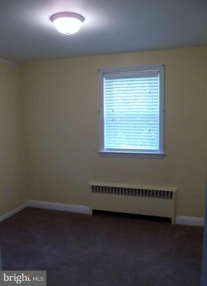 8412 Old Harford Road Baltimore, MD 21234 - Photo 14 of 25 an empty room with wooden floor and windows