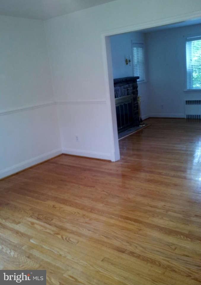 8412 Old Harford Road Baltimore, MD 21234 - Photo 5 of 25 a view of empty room with wooden floor and fireplace