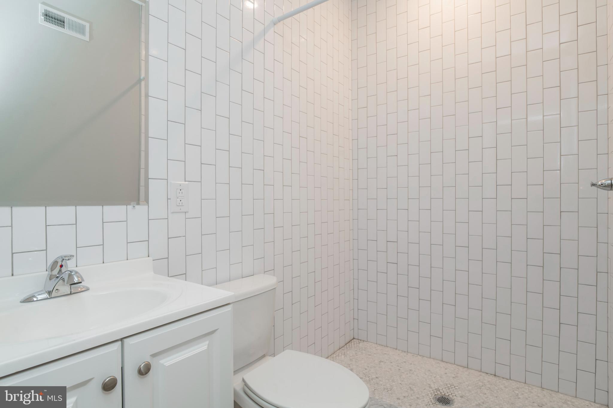 2009 North Darien Street, Unit 2 Philadelphia, PA 19122 - Photo 16 of 22 a bathroom with a sink a toilet and mirror