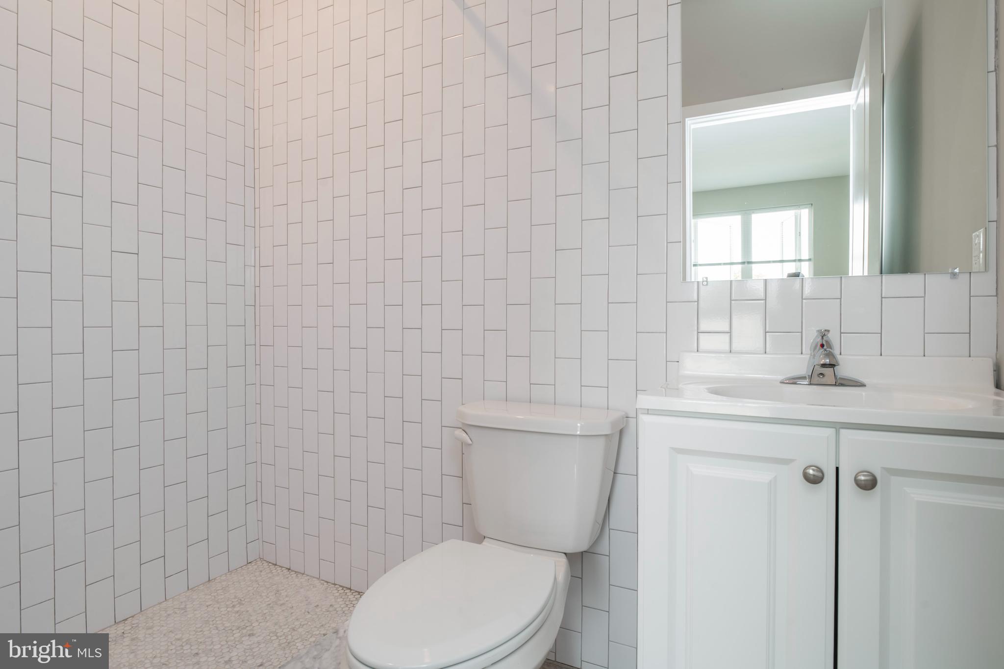 2009 North Darien Street, Unit 2 Philadelphia, PA 19122 - Photo 20 of 22 a bathroom with a toilet a sink and mirror