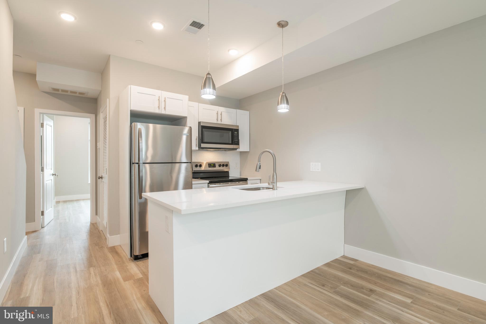 2009 North Darien Street, Unit 2 Philadelphia, PA 19122 - Photo 5 of 22 a kitchen with kitchen island a sink appliances and cabinets