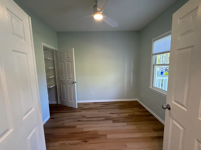 an empty room with wooden floor and windows