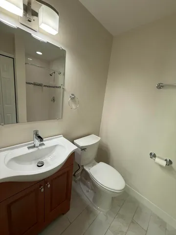 a bathroom with a sink a toilet and mirror