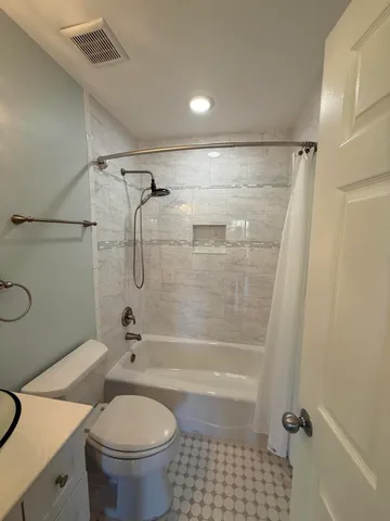 a bathroom with a shower a toilet and a shower