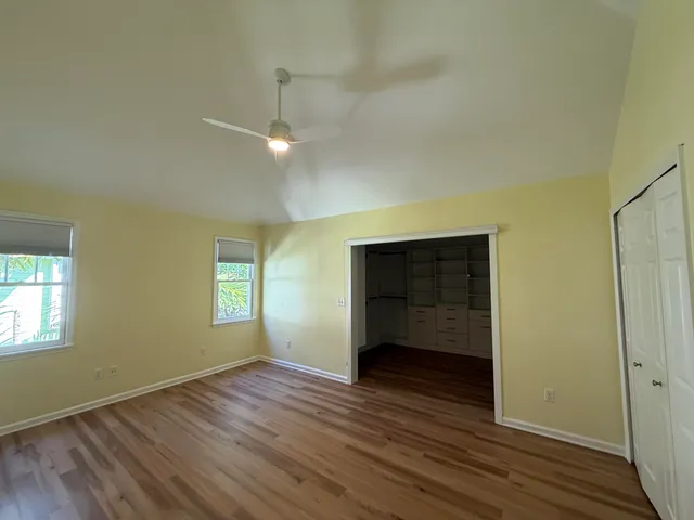 an empty room with wooden floor and windows