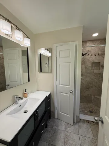 a bathroom with a double vanity sink mirror and shower