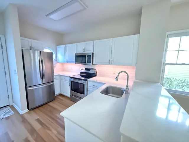 a kitchen with stainless steel appliances a refrigerator sink and cabinets