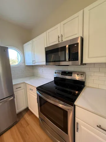 a kitchen with cabinets stainless steel appliances and a counter space