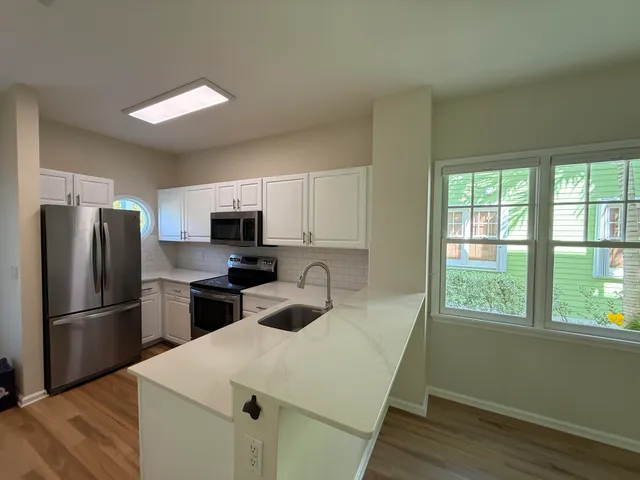 a kitchen with appliances a sink and a refrigerator
