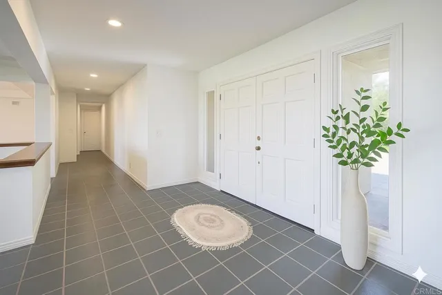 a living room with furniture potted plant and a large window