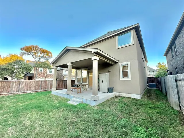 a backyard of a house with table and chairs