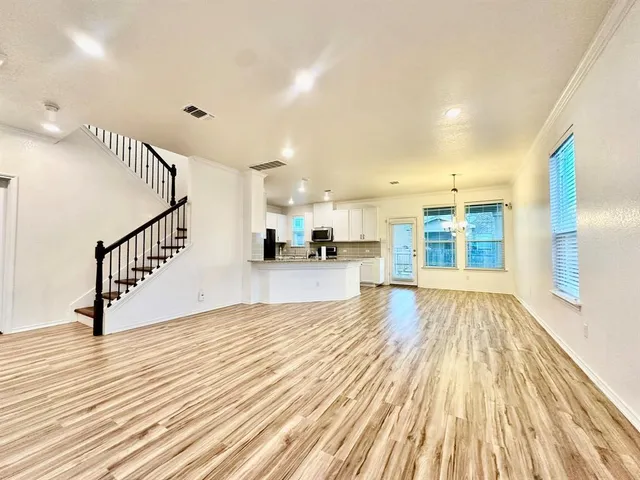 a view of empty room with wooden floor and windows