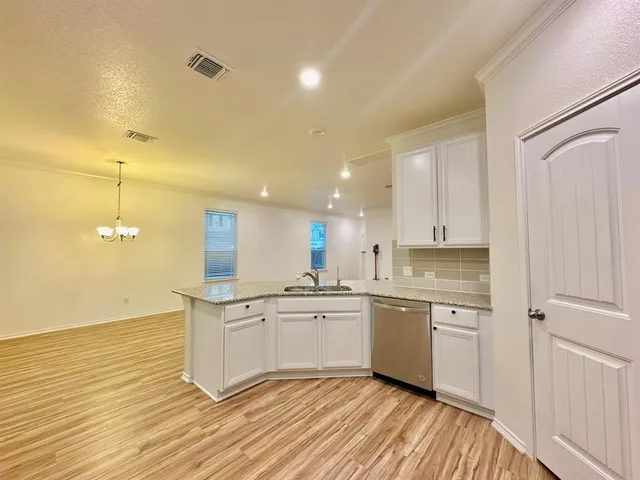 a kitchen with a sink cabinets and wooden floor