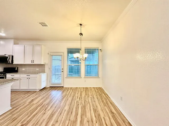 a open kitchen with a white countertops and wooden floor