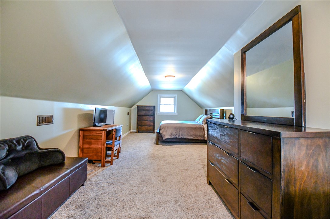 816 South Smithville Road Dayton, OH 45403 - Photo 23 of 33 This cozy bedroom features sloped ceilings, a single window, and warm carpet flooring.