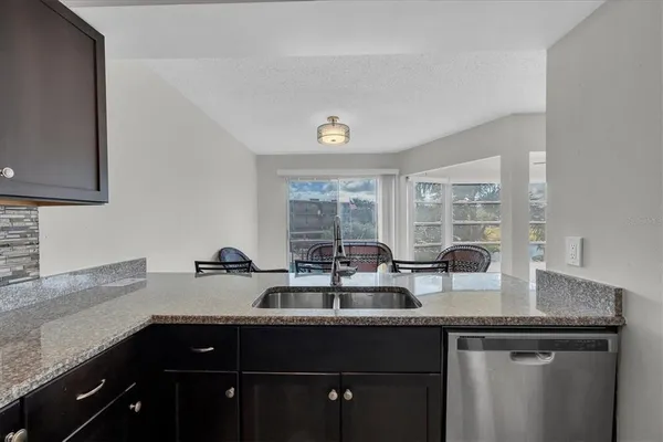 a kitchen with granite countertop a sink stainless steel appliances and a counter space