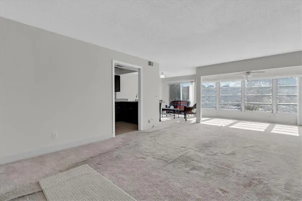 a view of a livingroom with furniture and floor to ceiling window