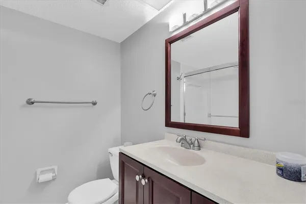a bathroom with a sink vanity mirror and toilet