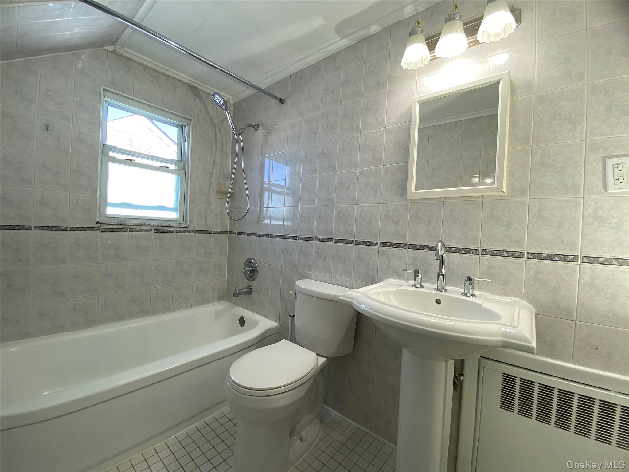 216 Raff Avenue Mineola, NY 11501 - Photo 16 of 20 a bathroom with a sink toilet a mirror and bathtub