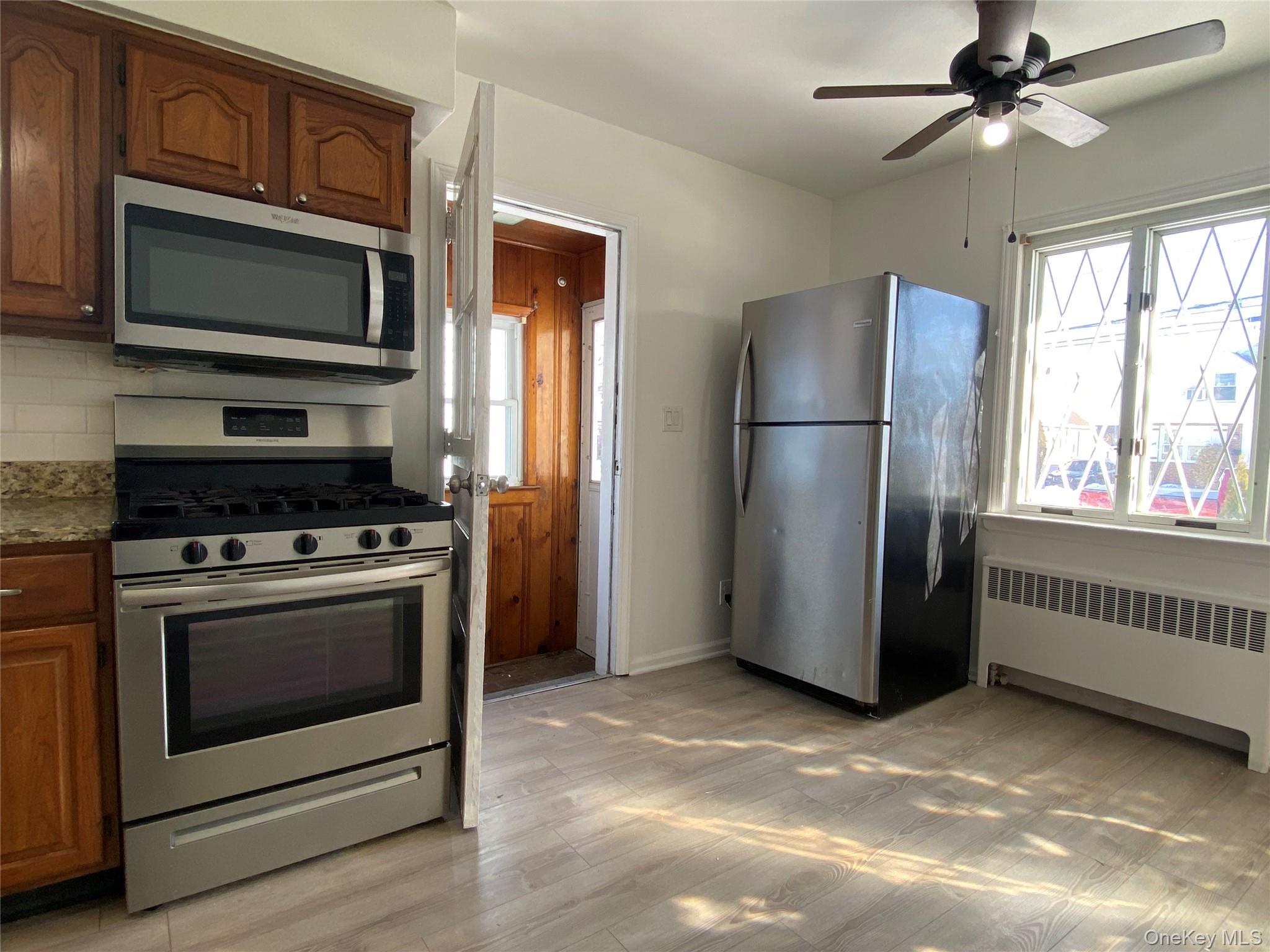216 Raff Avenue Mineola, NY 11501 - Photo 6 of 20 a kitchen with stainless steel appliances a stove a microwave and a refrigerator