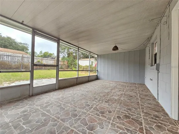 a view of a backyard with large trees and wooden fence