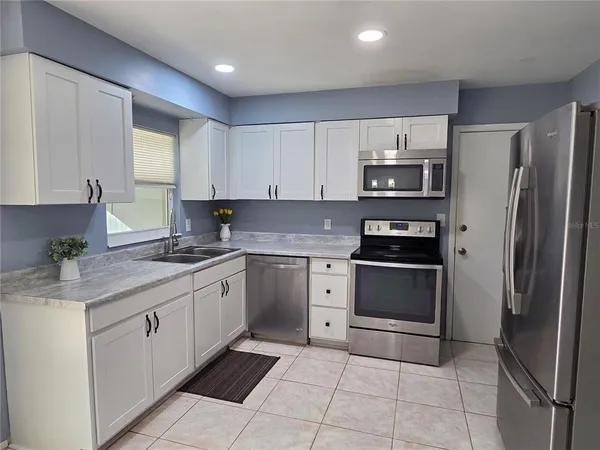 a kitchen with stainless steel appliances granite countertop a refrigerator and a stove top oven