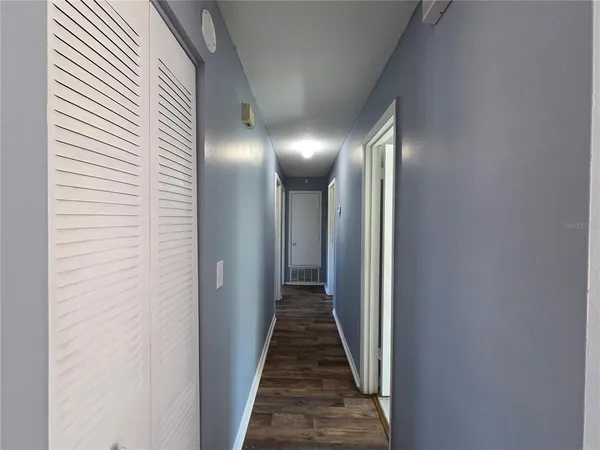 a view of a hallway with wooden floor