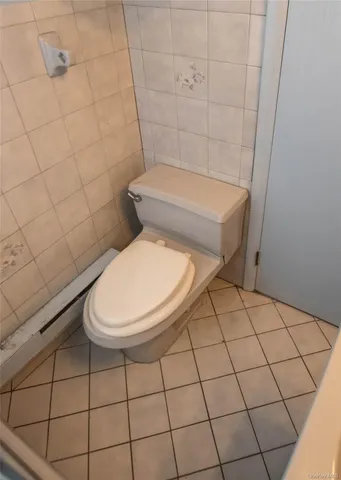 a white toilet sitting next to a white wall