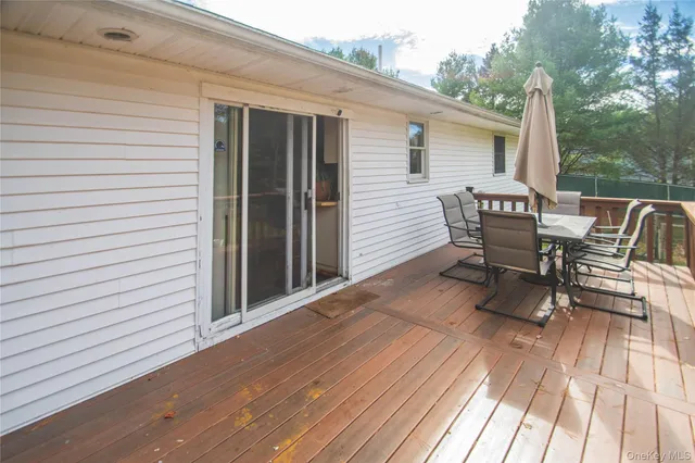 a view of a patio with table and chairs with wooden floor and fence