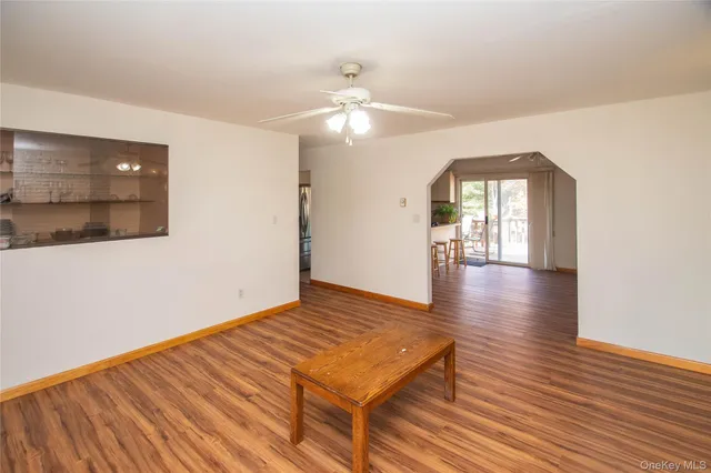 a view of a room with wooden floor and ceiling fan