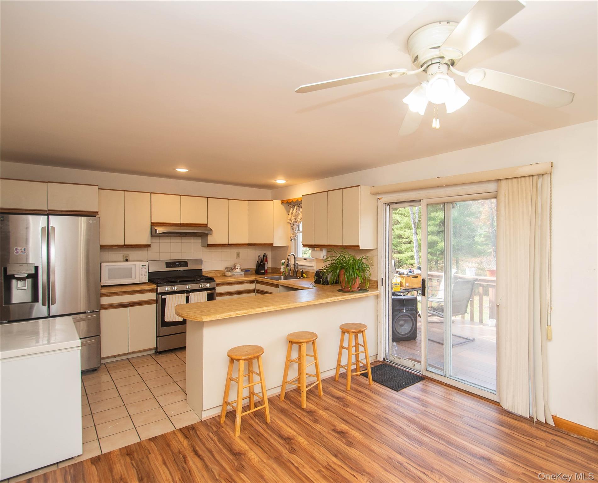 20 Valley Road Forestburgh, NY 12777 - Photo 8 of 38 Kitchen featuring appliances with stainless steel finishes, tasteful backsplash, a ceiling fan, light countertops, and a breakfast bar area