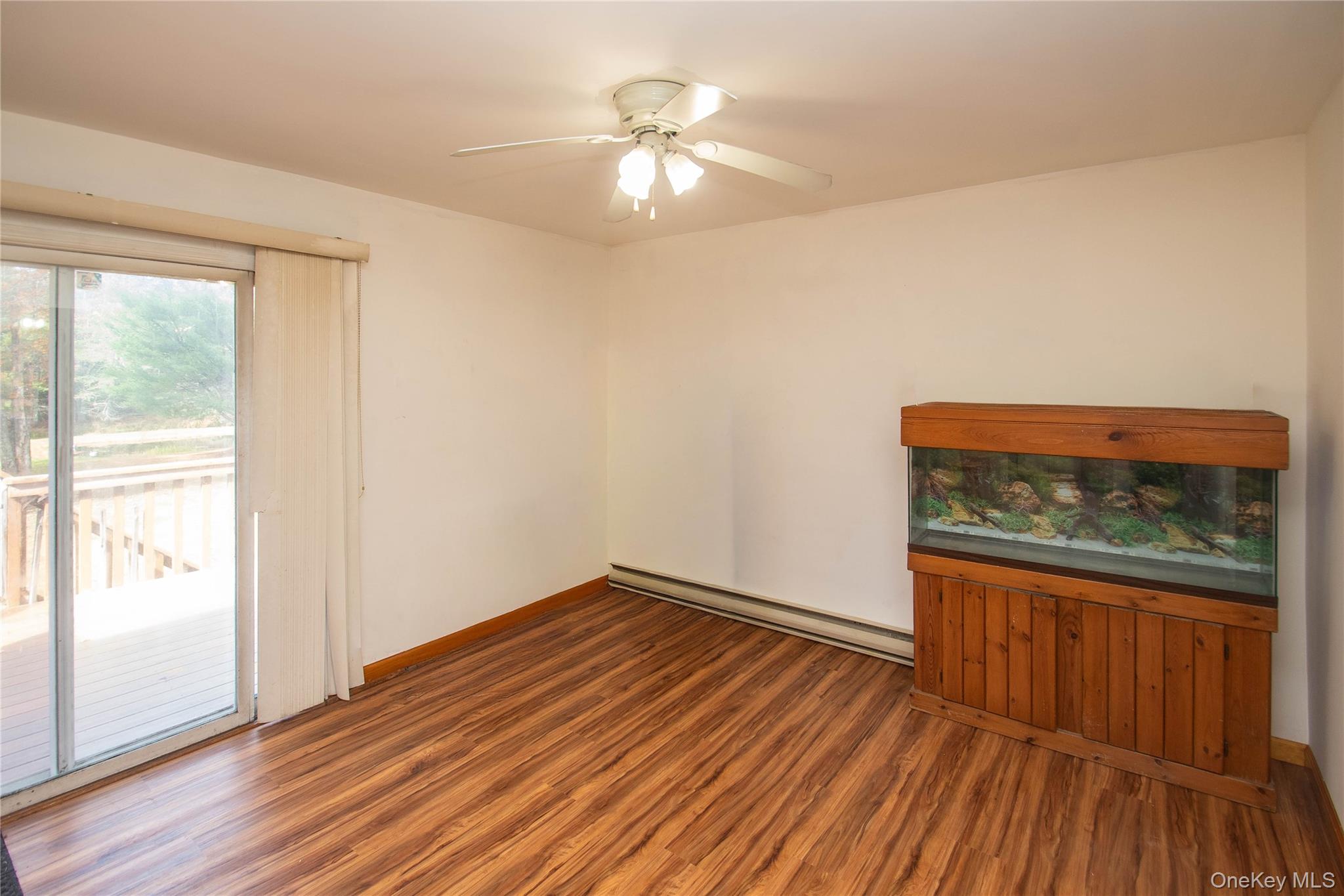 20 Valley Road Forestburgh, NY 12777 - Photo 9 of 38 Unfurnished room with wood finished floors, a baseboard radiator, and ceiling fan